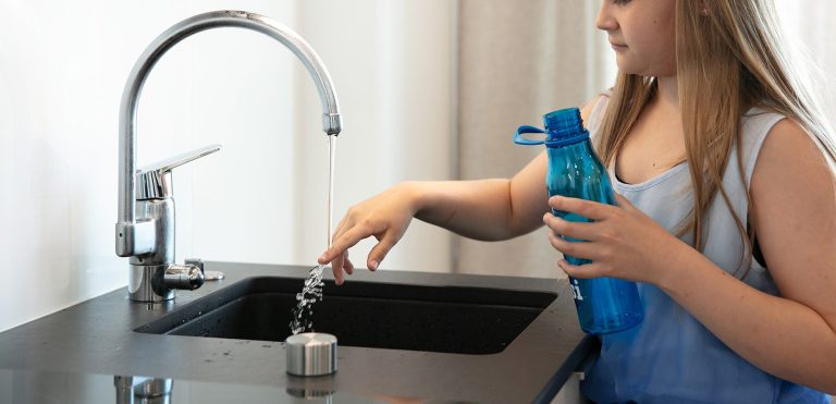 Tyttö ja vesipullo.